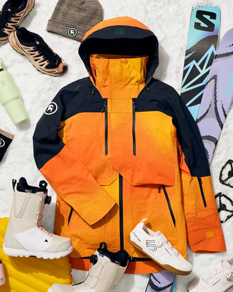 Outdoor gear and apparel from Backcountry laid out on snow